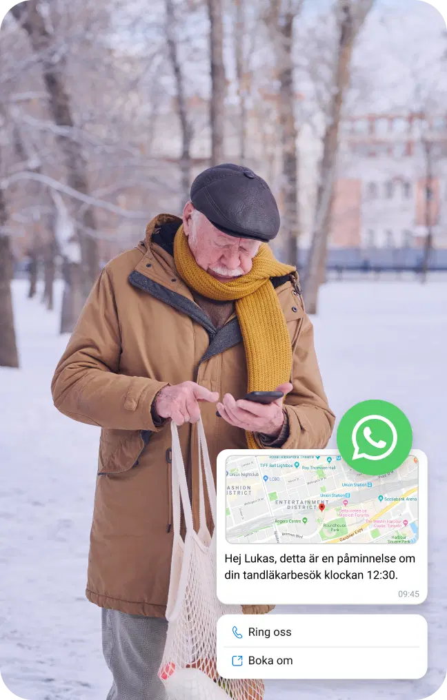 Äldre man i snön letar efter sin mobils plats via WhatsApp-företagsmeddelande
