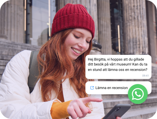 Tjej med röd keps läser ett WhatsApp Business-meddelande på sin telefon
